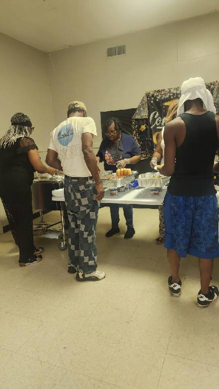 Volunteers serving food to community members at an indoor gathering