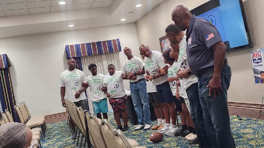 Young football players and mentors standing together during a community program