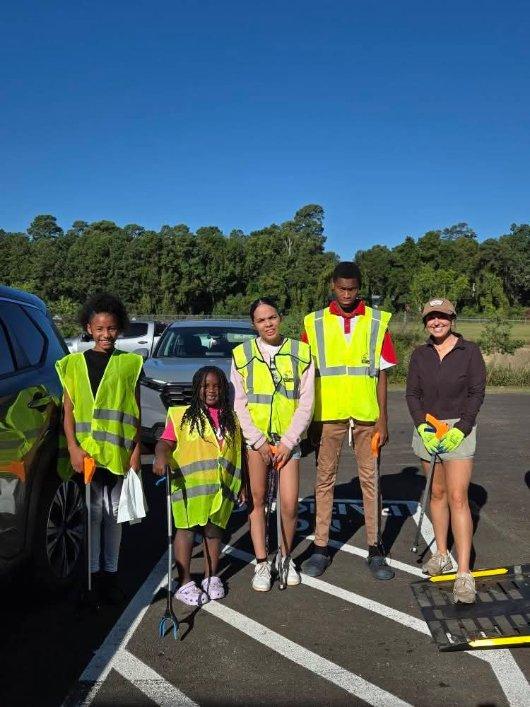 Young volunteers wearing safety vests during a community cleanup