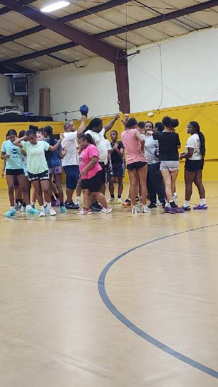 Young athletes gathering in a huddle on a gym court